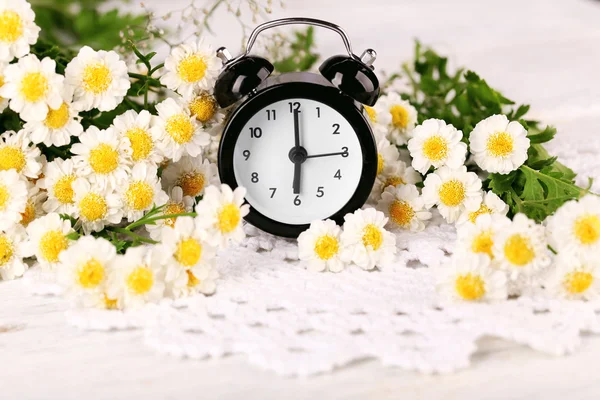 Pequeño despertador con hermosas flores — Foto de Stock