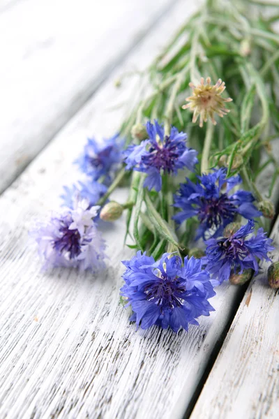 Blauwe wilde bloemen op houten tafel — Stockfoto