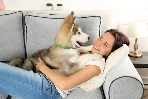 Woman lying with her malamute dog — Stock Photo, Image