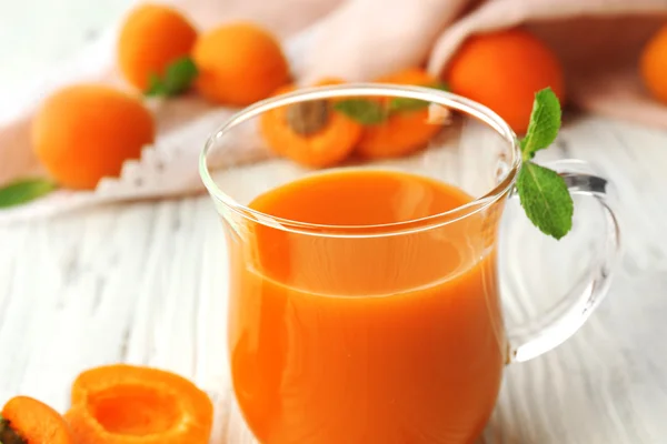 Cup of apricot juice and fresh fruits — Stock Photo, Image