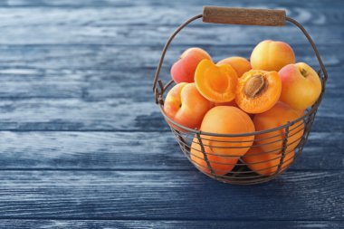 Ahşap masa üzerinde metal sepet üzerinde olgun kayısı yakın çekim