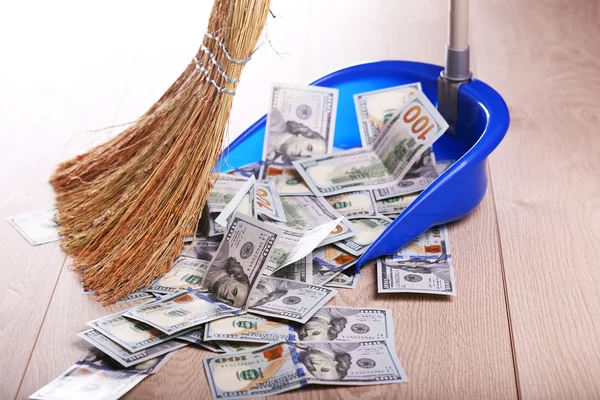 Broom sweeping dollars in scoop — Stock Photo, Image