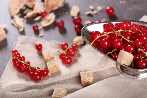 Groselhas vermelhas maduras com açúcar de lâmpada na mesa com pano de saco, close-up — Fotografia de Stock