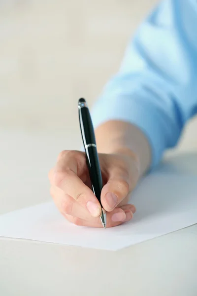 Mão feminina com caneta escrita em papel — Fotografia de Stock