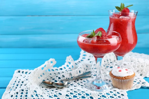 Frysta jordgubbar efterrätt i glas, på färg trä bakgrund — Stockfoto