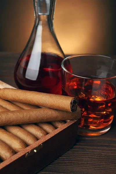 Zigarren mit Glas Cognac auf Holztisch, Nahaufnahme — Stockfoto