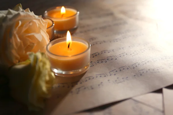 Rose avec des bougies sur les feuilles de musique — Photo