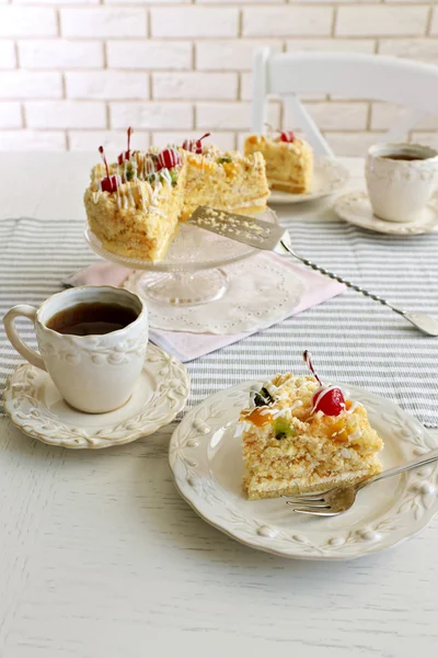 Butter cake on plate, tea cups — Stock Photo, Image