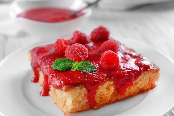 Pastel fresco con mermelada de frambuesa en platillo blanco — Foto de Stock