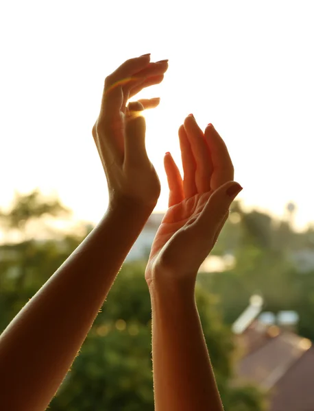 Mãos femininas sobre o céu por do sol — Fotografia de Stock