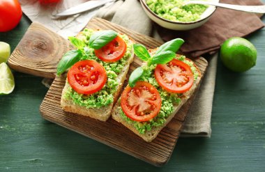 avokado ve ahşap arka plan üzerinde kesme tahtası üzerinde sebze vejetaryen sandviç