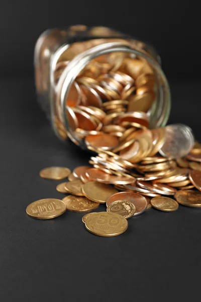 Glass jar with coins on dark background — Stock Photo, Image