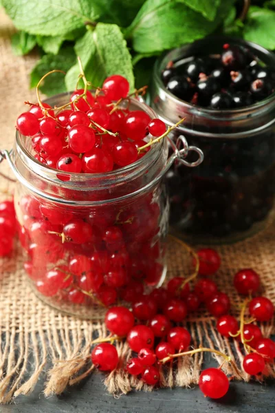 Ripe forest berries in glass jar  on wooden background — Stock Photo, Image