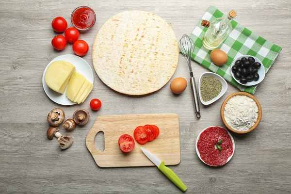 Ingrédients pour cuisiner la pizza sur une table en bois, vue de dessus — Photo