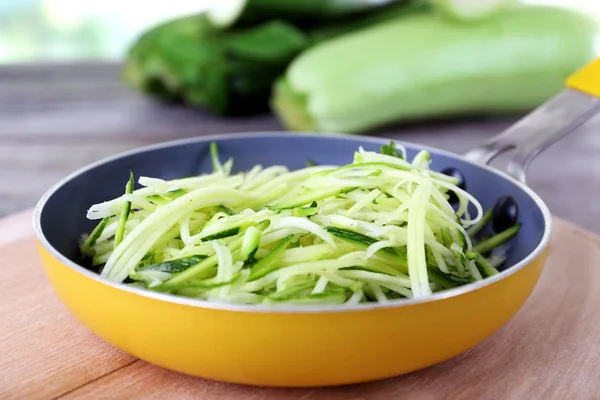 Grated zucchini and squash in pan on wooden table close up — Stock Photo, Image