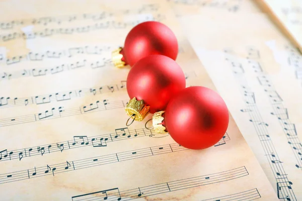 Christmas ball on music sheets background — Stock Photo, Image