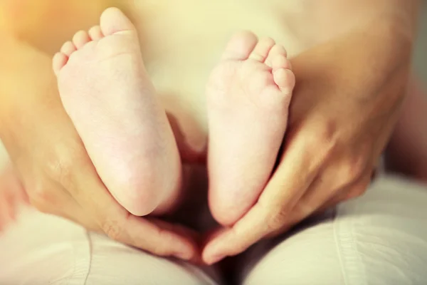Vuxna händer som håller baby fötter, närbild — Stockfoto
