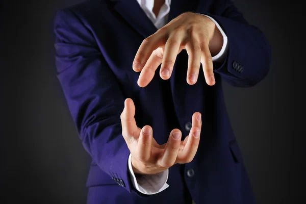 Businessman in suit introduce something on dark background — Stock Photo, Image