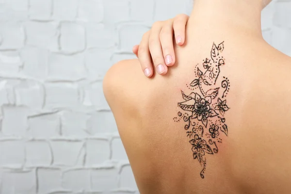 Back painted with henna - Mehendi on grey wall background — Stock Photo, Image