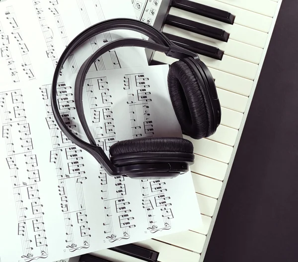 Headphones with music notes on synthesizer close up — Stock Photo, Image