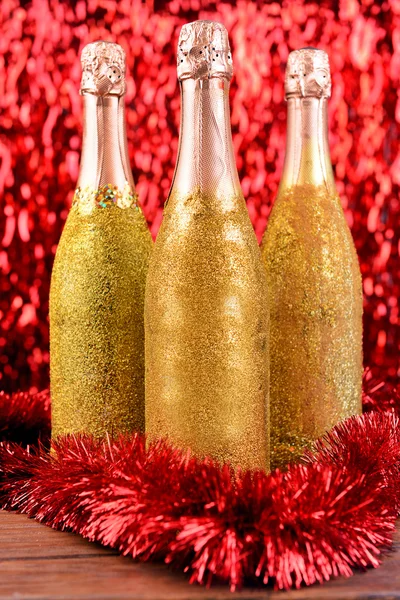 Bottles of champagne with Christmas decoration on bright background — Stock Photo, Image