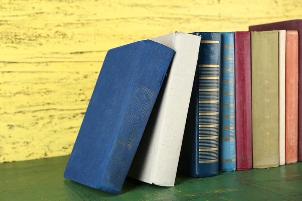 Buku-buku retro pada latar belakang kayu kuning — Stok Foto