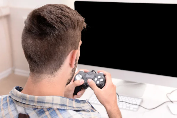 Jovem jogando jogos de computador em casa — Fotografia de Stock