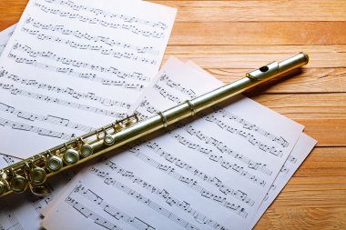 Ahşap masa üzerine müzik notlar ile gümüş flüt yakın çekim