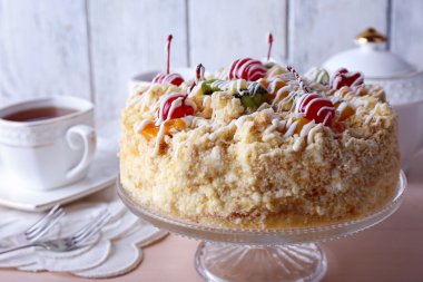 Tereyağı kek kiraz stand ve renk ahşap arka plan üzerinde tablo ayarı ile