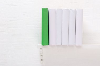 Boş kitap ve beyaz raf üstünde yeşil bir arka plan duvar kağıdı
