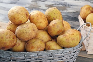 Ahşap masa hasır sepetleri genç patates yakın çekim