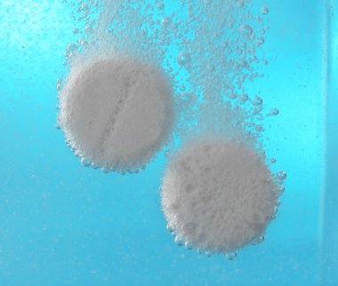 Effervescent painkiller tablets in water, closeup clipart