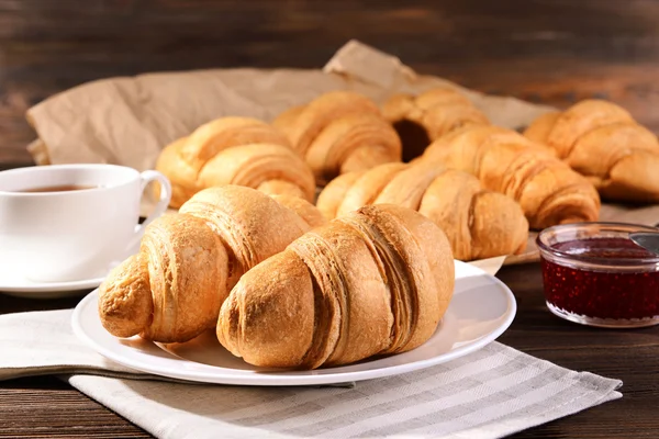 Deliciosos croissants na placa na mesa close-up — Fotografia de Stock