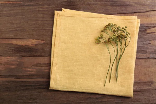 Hermosas flores secas en servilleta sobre fondo de madera —  Fotos de Stock