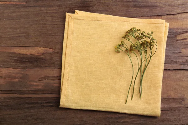 Belles fleurs sèches sur serviette sur fond en bois — Photo