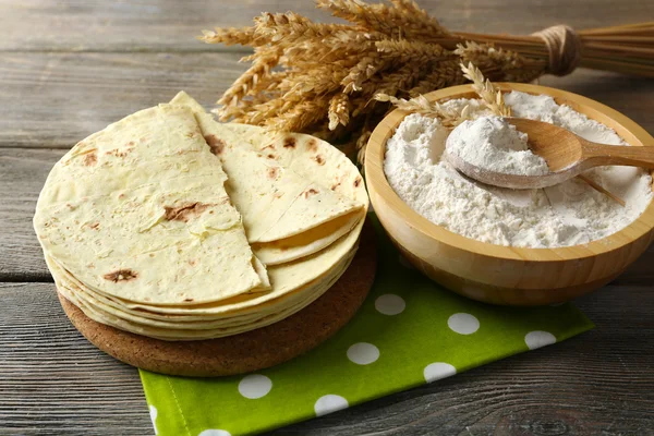 Bunt med hemgjord hela vete mjöl tortilla på skärbräda, på träbord bakgrund — Stockfoto