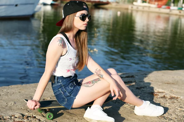 Hermosa chica tatuada con monopatín, al aire libre — Foto de Stock