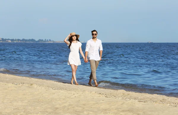 Pareja joven caminando en la playa —  Fotos de Stock