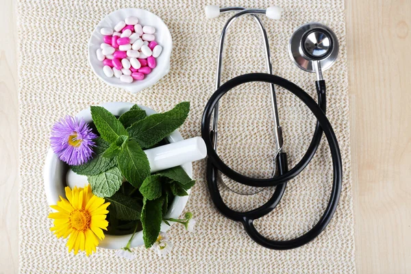 Médecine alternative herbes et stéthoscope sur fond de table en bois — Photo