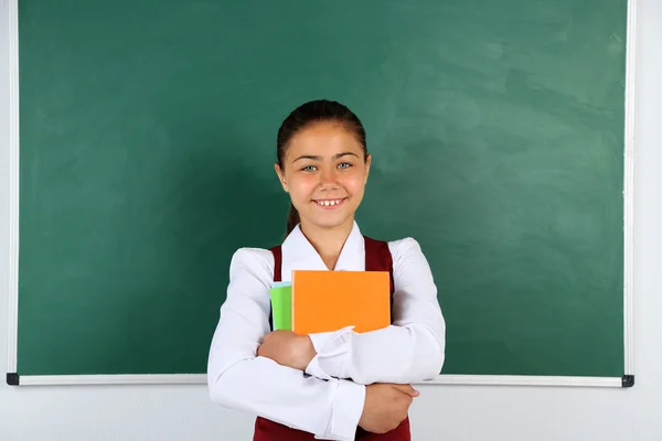 Piękna dziewczyna mały stojący w pobliżu tablicy w klasie — Zdjęcie stockowe