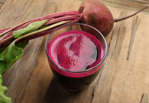 Jugo de remolacha fresca en la mesa de madera, primer plano — Foto de Stock