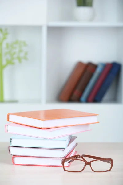 Stapel boeken met een bril op houten tafel op kamer — Stockfoto