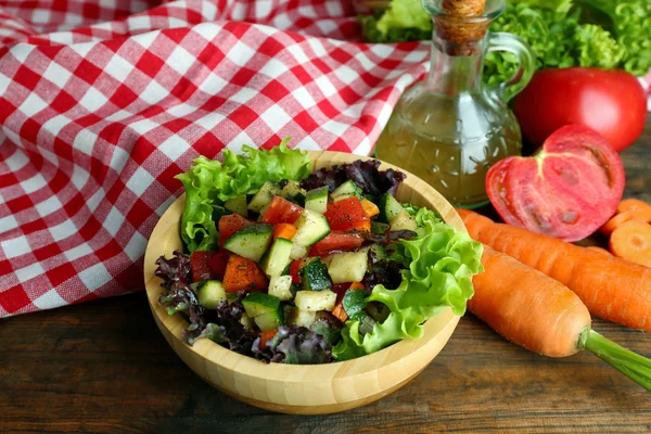 Wooden bowl of fresh vegetable salad on wooden table, closeup — Stock Photo, Image