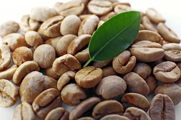 Heap de grãos de café verde com folha de perto — Fotografia de Stock