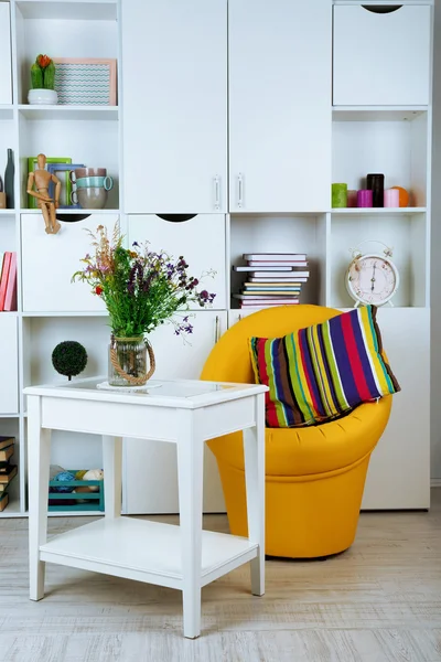 Белая гостиная с креслом и книжным шкафом — стоковое фото