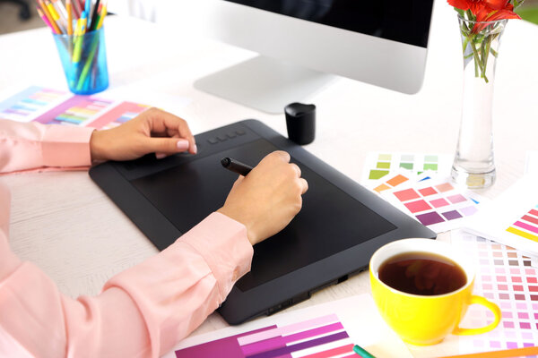 Artist drawing on graphic tablet in office