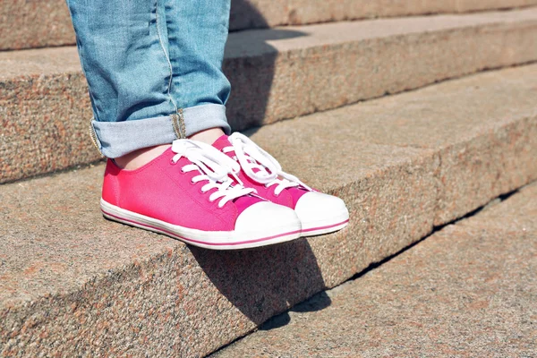 Pies femeninos en zapatos de goma rosa en escaleras de piedra — Foto de Stock