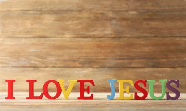 Eu amo o sinal de JESUS ilustrado com letras plásticas coloridas no fundo de madeira — Fotografia de Stock
