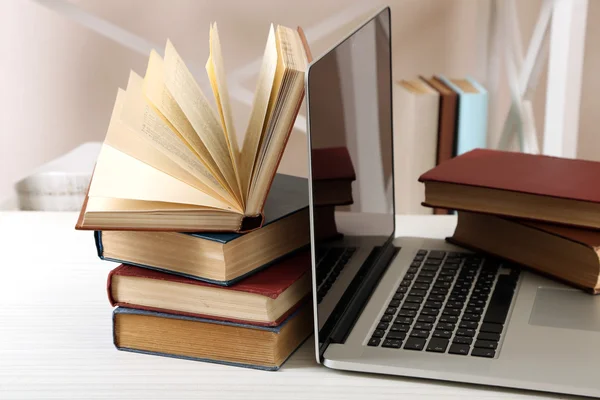 Stapel boeken met laptop op tafel close-up — Stockfoto