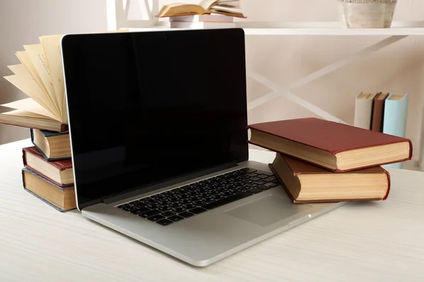 Stack of books with laptop on table close up — Stock Photo, Image